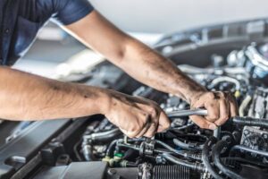 meccanico che lavora sul motore dell'auto