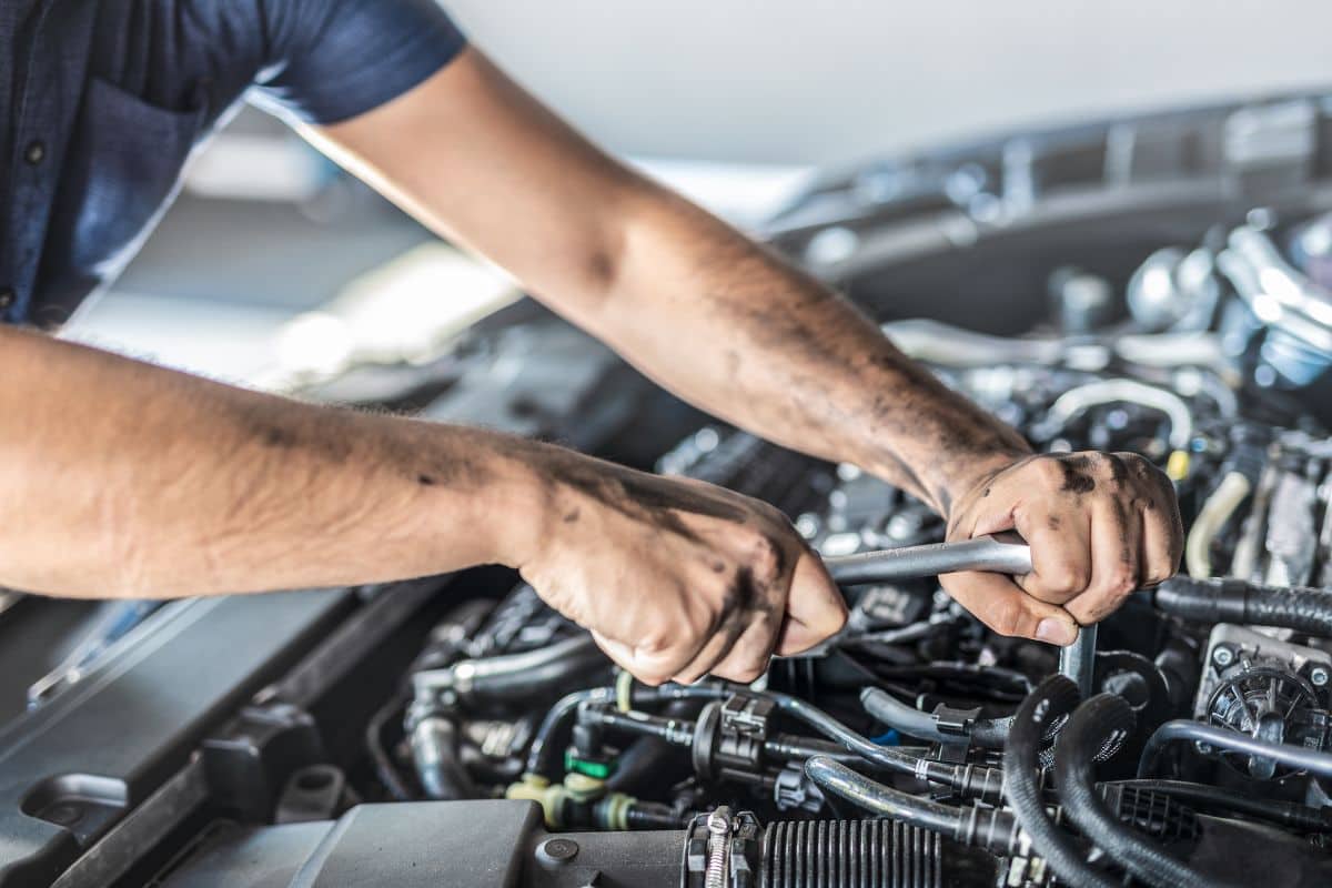 meccanico che lavora sul motore dell'auto