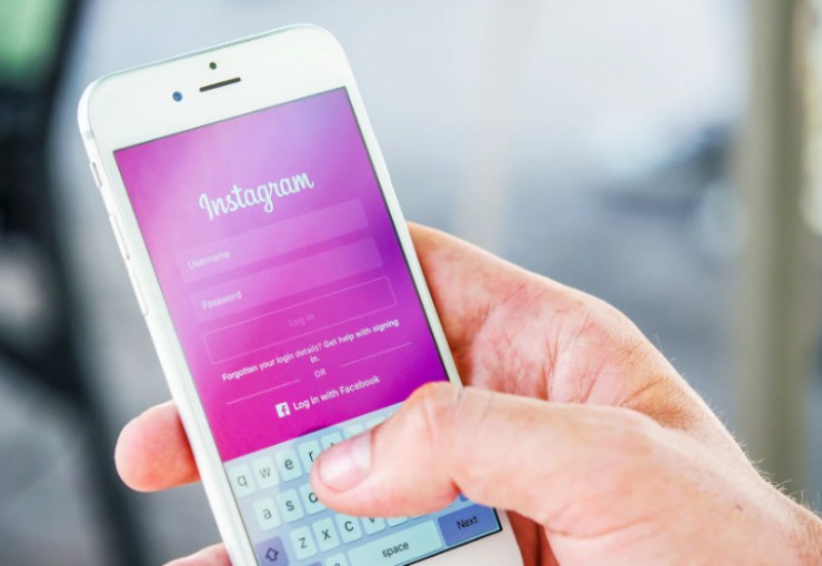 persona con in mano il cellulare su Instagram